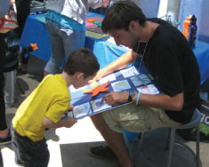 Graduate student explaining his poster to a child