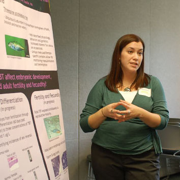 A conference attendee discusses her poster
